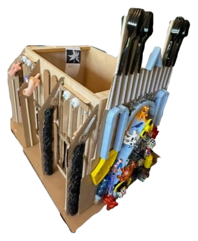 Raw plywood cathedral model with toys attached